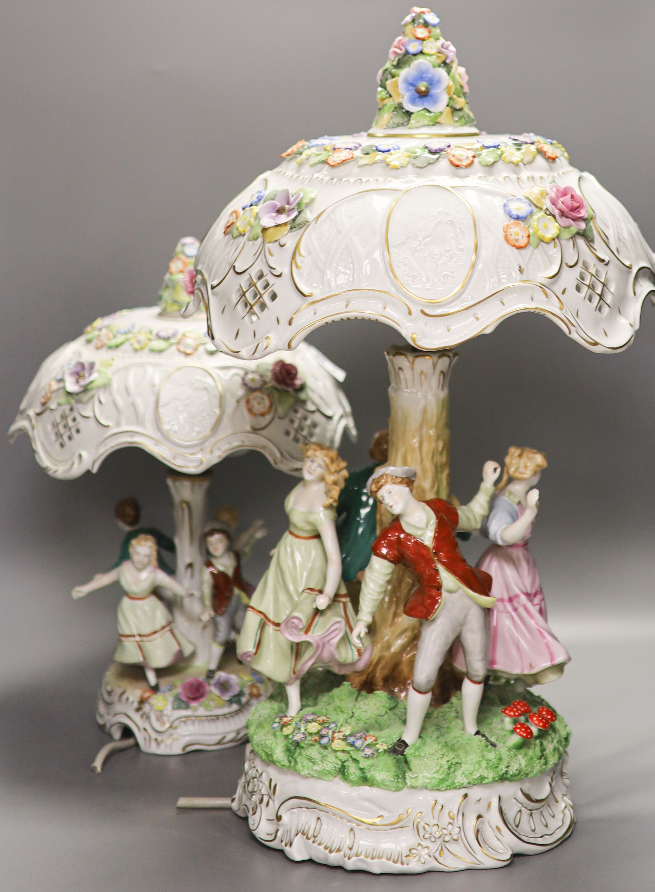 Two pairs of German porcelain table lamps, the stems modelled with figures dancing 56cm